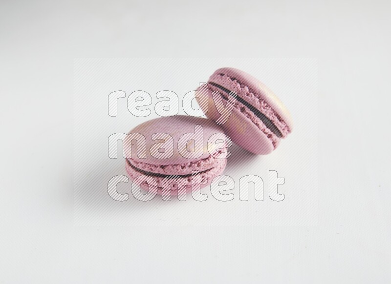 45º Shot of two Purple Strawberry macarons on white background