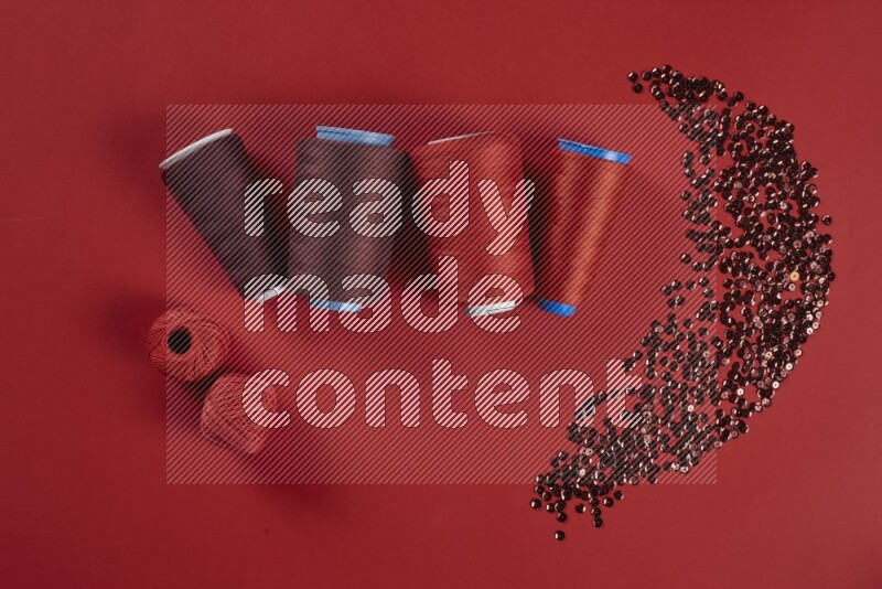 A red collection of sewing and tailoring tools arranged on a red background