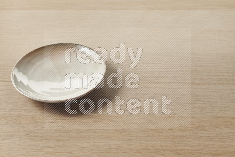 Beige Pottery Plate on Oak Wooden Flooring, 45 degrees