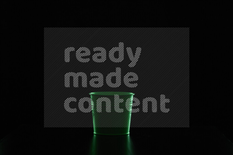 A plant pot with colored rim light against black background