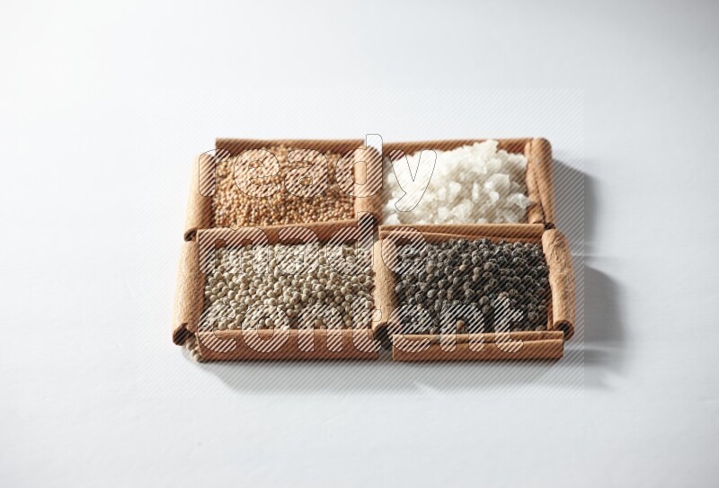 4 squares of cinnamon sticks full of mustard, salt, white pepper and black pepper on white flooring