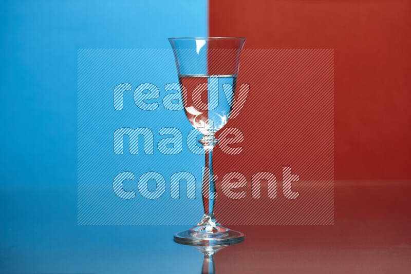 The image features a clear glassware filled with water, set against blue and red background