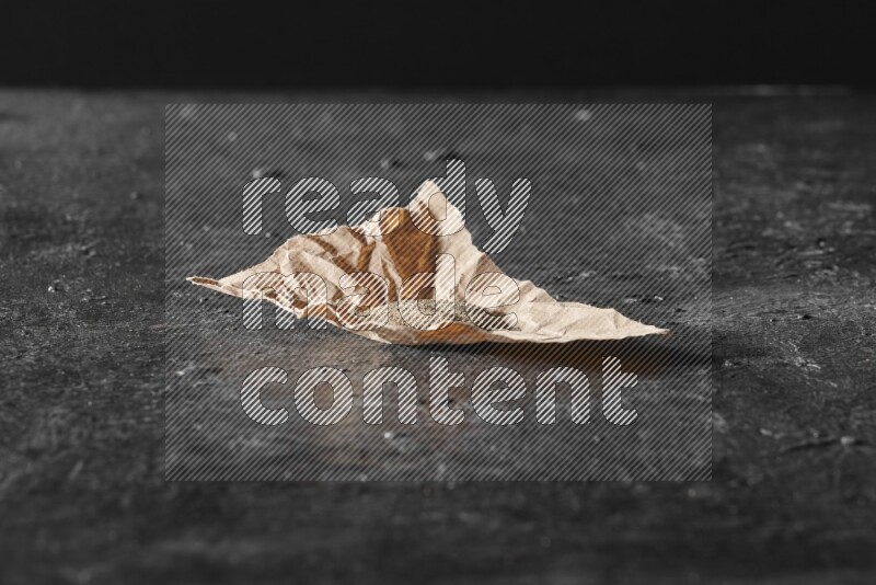 بودرة الفلفل الأسود في قطعة من الورق علي خلفية سوداء