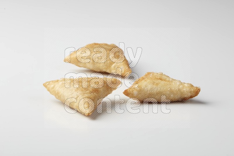 Three fried sambosas on a white background