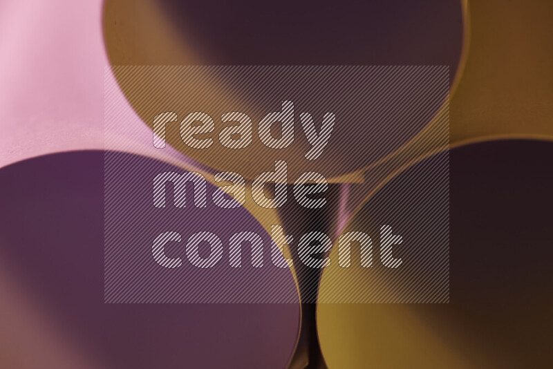 الصورة تعرض فن ورقي تجريدي بأشكال دائرية بدرجات متنوعة من اللون الوردي والدرجات الدافئة