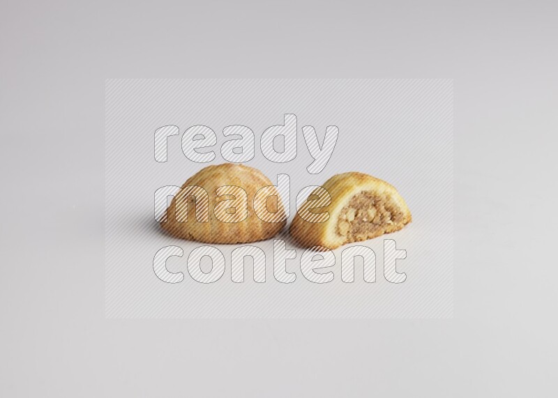 Two Pieces of Maamoul filled with walnut paste  one of them is cut direct on white background