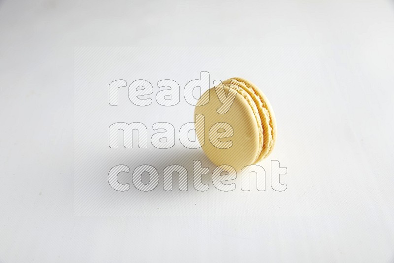 45º Shot of Yellow Vanilla macaron on white background