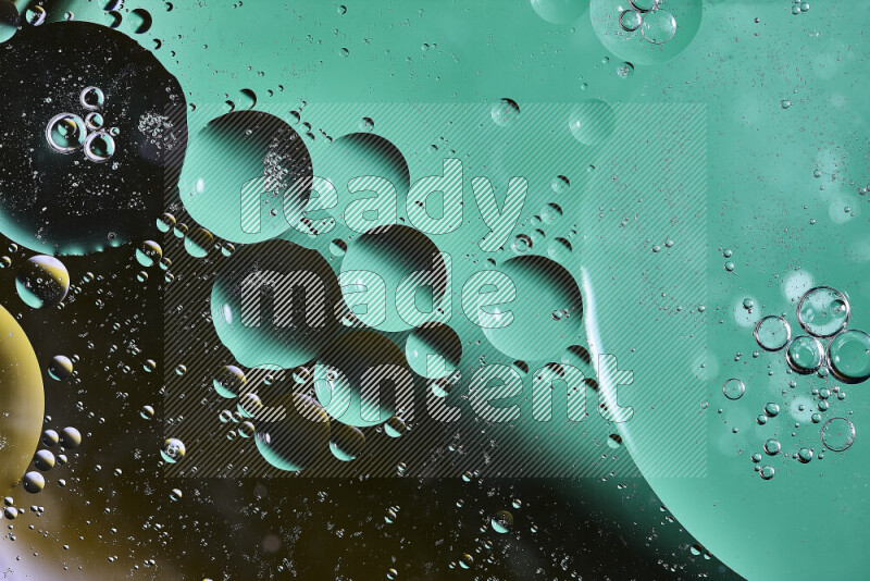Close-ups of abstract oil bubbles on water surface in shades of green, black and yellow