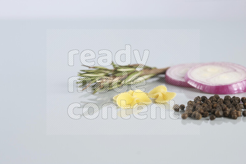 Raw pasta with different ingredients such as cherry tomatoes, garlic, onions, red chilis, black pepper, white pepper, bay laurel leaves, rosemary, cardamom and mushrooms on light blue background