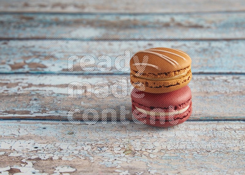 45º Shot of of two assorted Brown Irish Cream, and Red Velvet macarons on light blue background