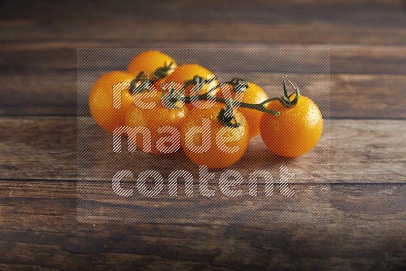 yellow cherry tomato vein on a textured wooden background 45 degree