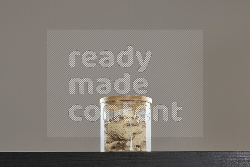 Dried ginger in a glass jar on black background