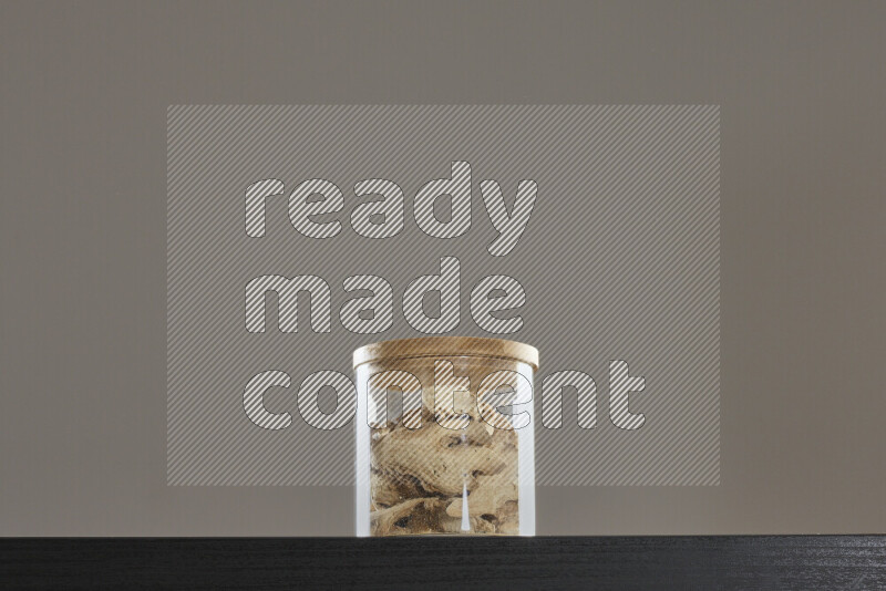 Dried ginger in a glass jar on black background