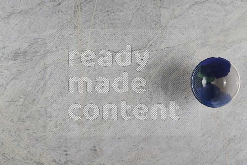 وعاء فخاري متعدد الألوان على خلفية من الرخام الرمادي