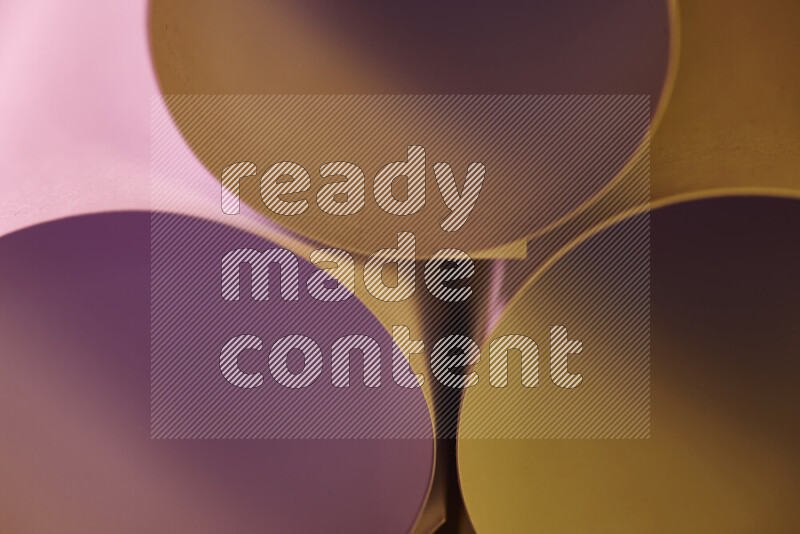 الصورة تعرض فن ورقي تجريدي بأشكال دائرية بدرجات متنوعة من اللون الوردي والدرجات الدافئة