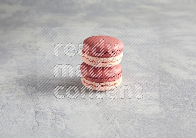45º Shot of two Pink Litchi Raspberry macarons  on white  marble background
