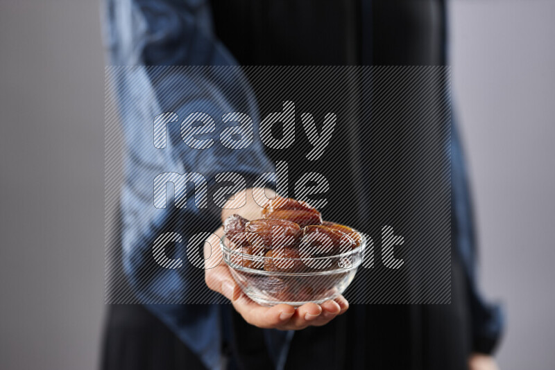 Woman in abaya holding dates in different positions