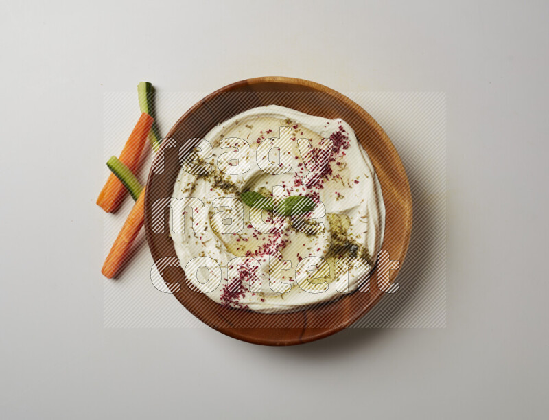 Lebnah garnished with  zattar , sumak & mint in a wooden plate on a white background