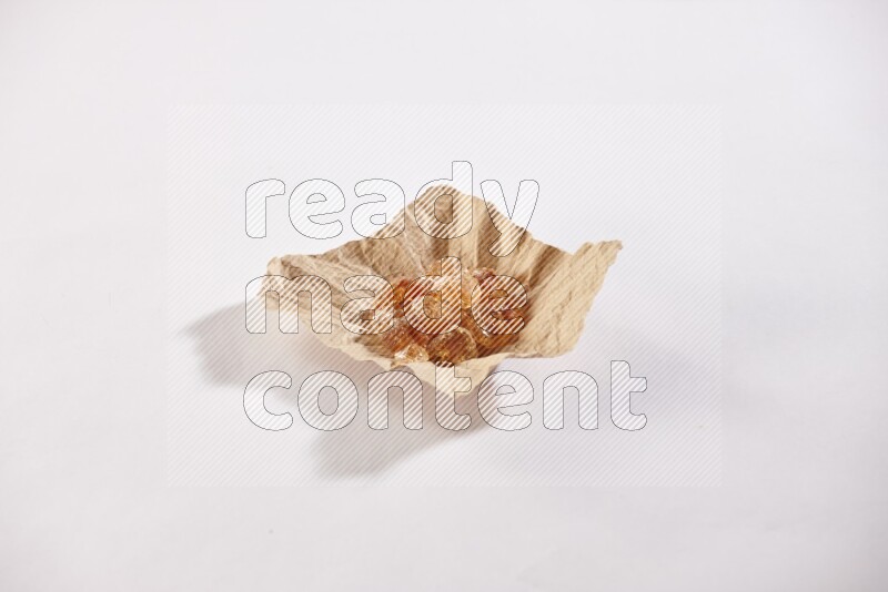 A crumpled piece of paper full of gum arabic on white flooring