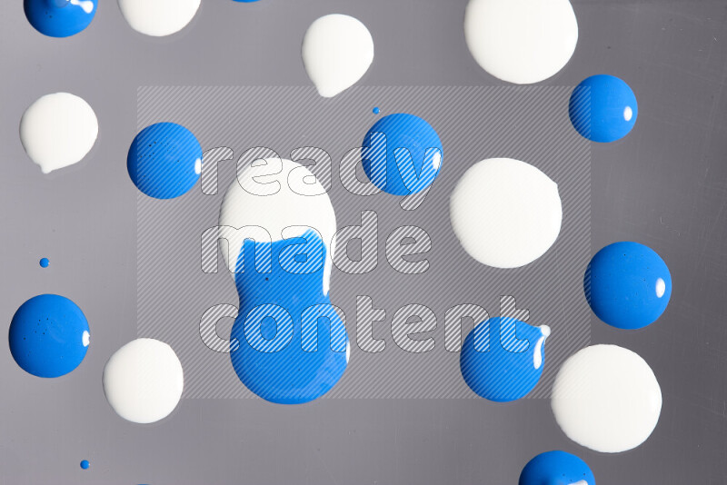 Close-ups of abstract white and blue paint droplets on the surface