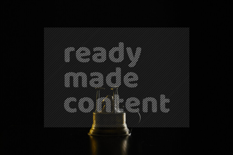 A turkish coffee maker with colored rim light against black background