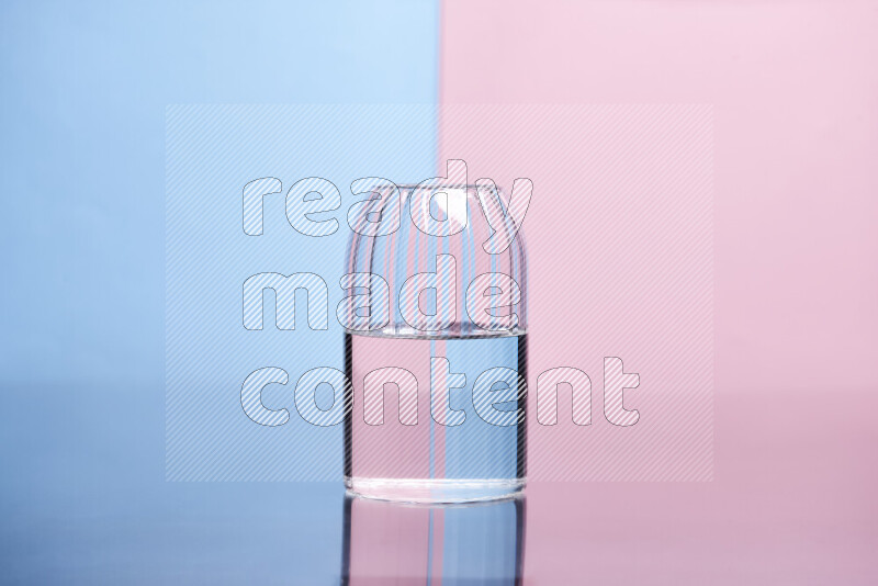 The image features a clear glassware filled with water, set against light blue and rose background