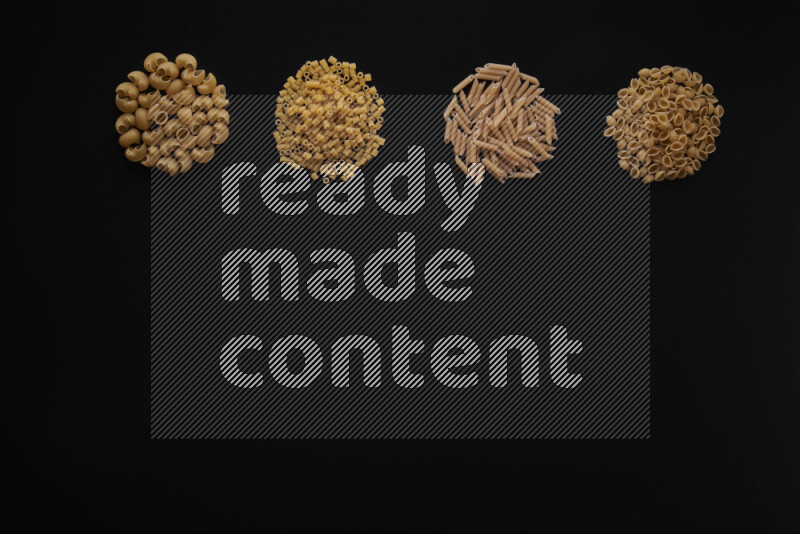 Different pasta types in 4 bunches on black background