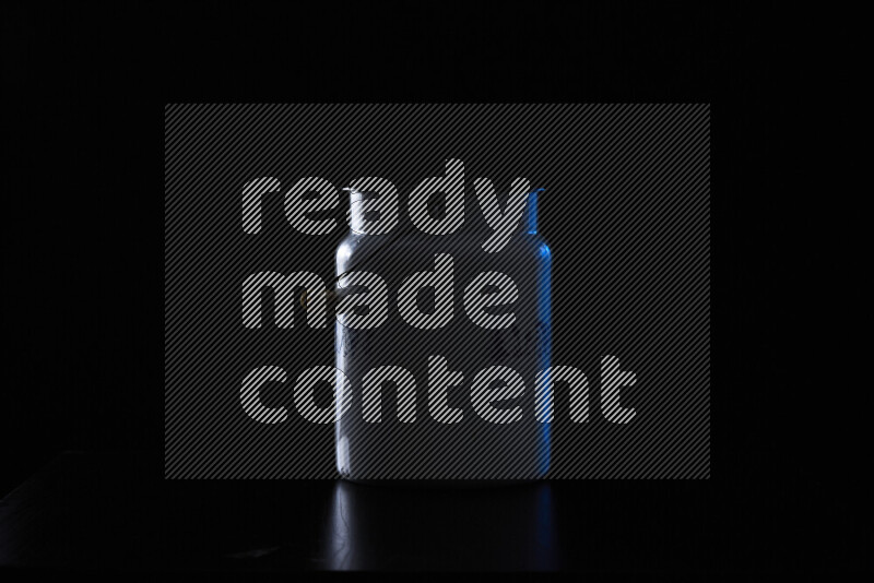 A vintage milk canister with colored rim light against black background