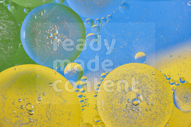 Close-ups of abstract oil bubbles on water surface in shades of yellow, green and blue