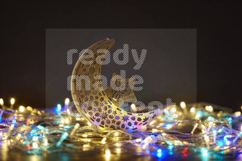 A traditional ramadan lantern surrounded by glowing fairy lights in a dark setup