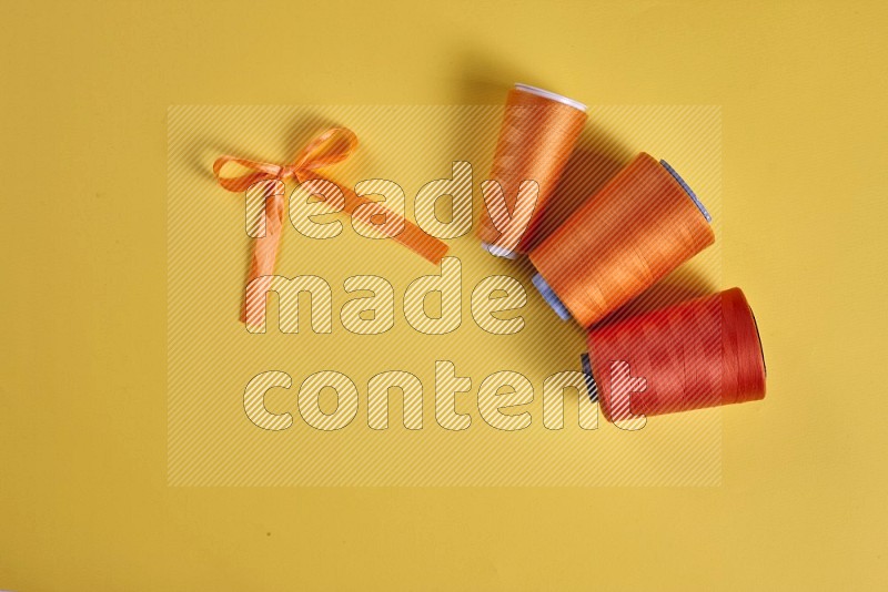 Orange sewing supplies on yellow background