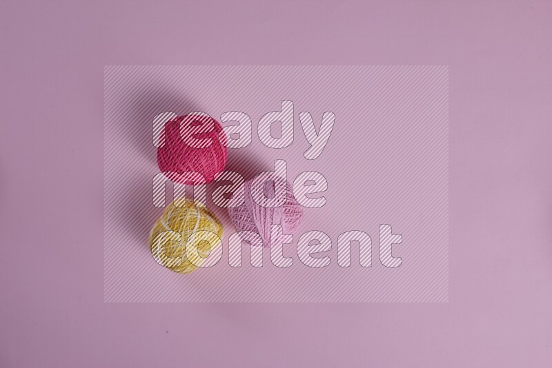 مجموعة من أدوات الخياطة والتفصيل صفراء وزهرية اللون على خلفية زهرية