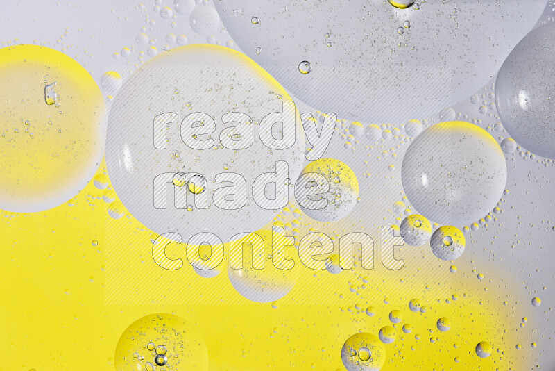 Close-ups of abstract oil bubbles on water surface in shades of white and yellow