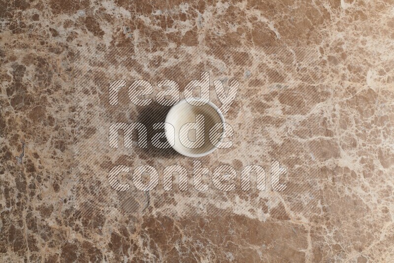 A pottery cup on beige marble background