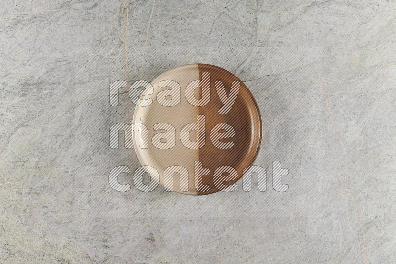 Top View Shot Of A Multicolored Pottery Oven Plate On Grey Marble Flooring