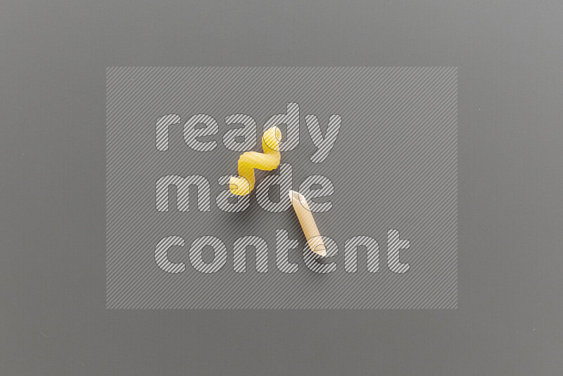 Twist pasta with other types of pasta on grey background