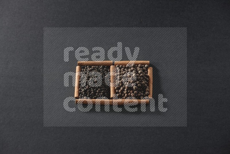 2 squares of cinnamon sticks full of black peppers and allspice on black flooring