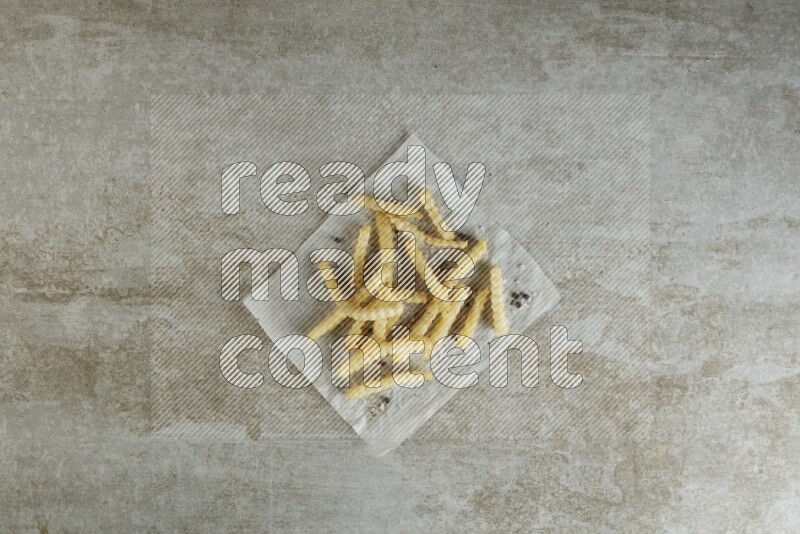 crinkle fries on parchment paper on grey textured counter top