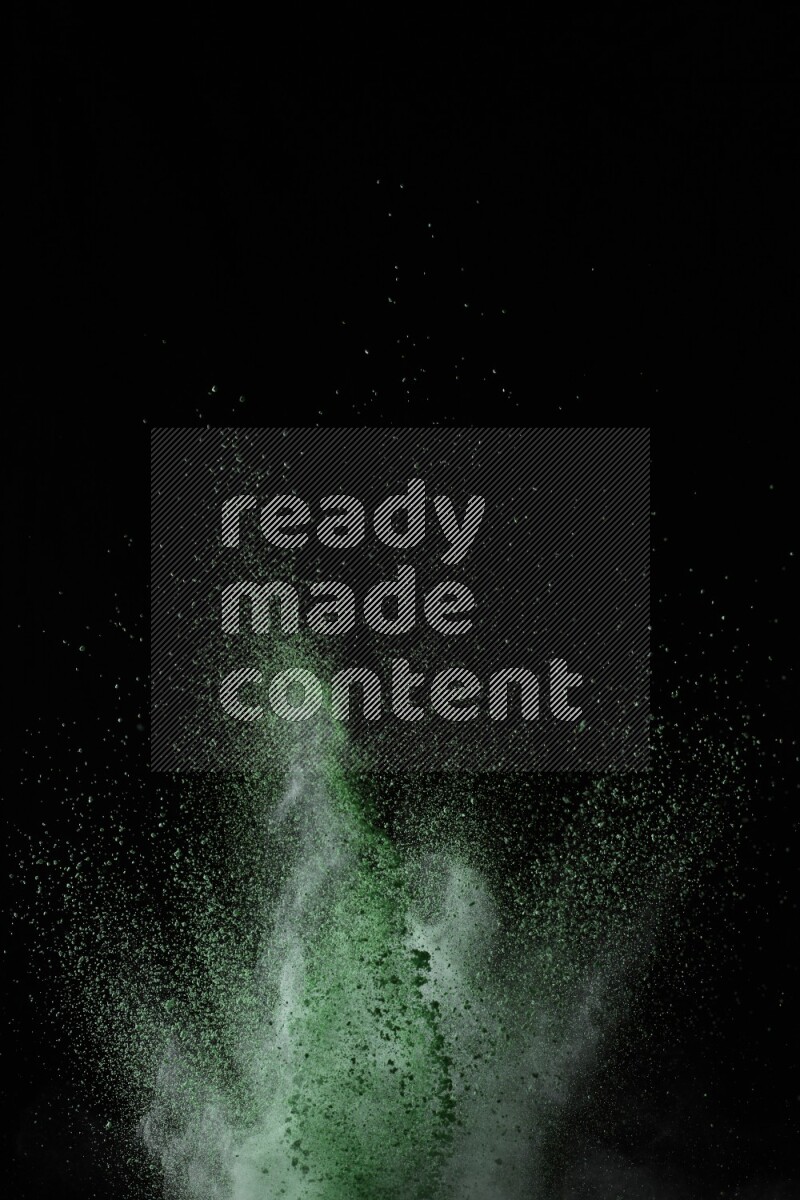A side view of green powder explosion on black background