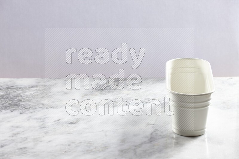An empty white plant pot on grey marble background