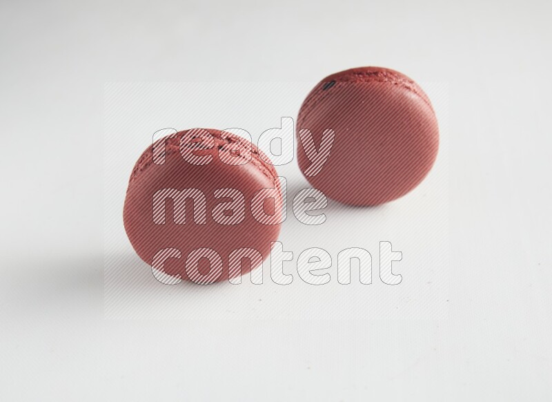 45º Shot of two Red Velvet macarons on white background
