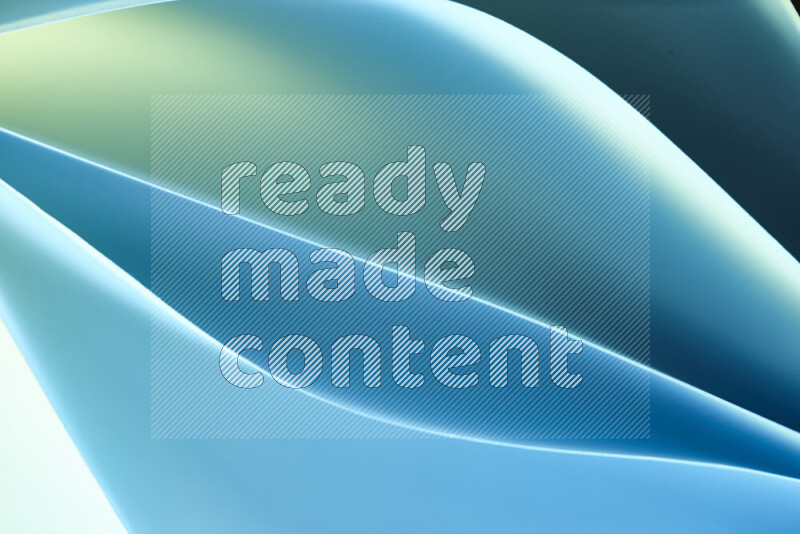 هذه الصورة تعرض تكوين فن الورق التجريدي مع منحنيات ورقية بتدرجات اللون الأخضر والأزرق المكونه بواسطة الضوء الملون