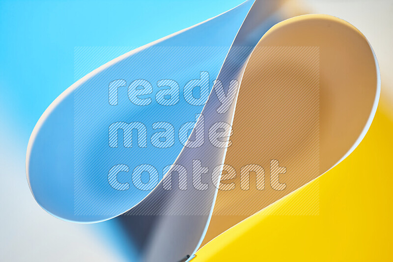 An abstract art of paper folded into smooth curves in blue and yellow gradients