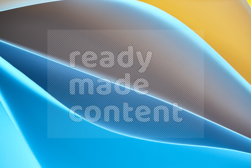 This image showcases an abstract paper art composition with paper curves in blue and yellow gradients created by colored light