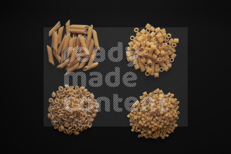 Different pasta types in bunches on black background