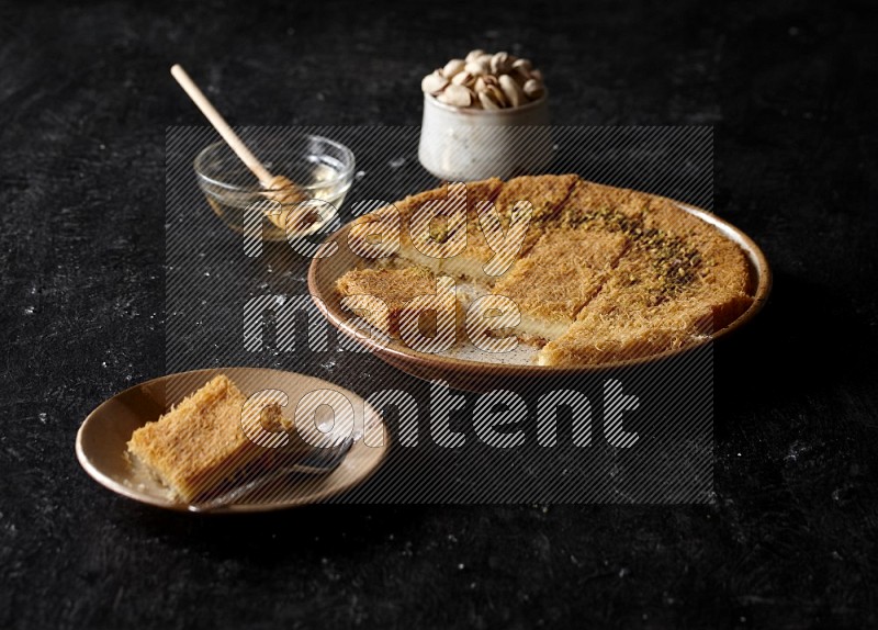 Konafa with nuts and honey in a dark setup