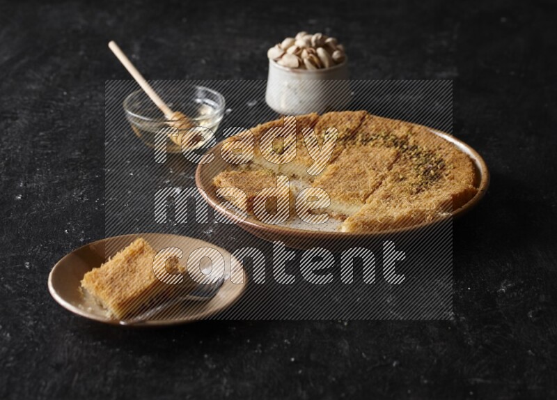 Konafa with nuts and honey in a dark setup