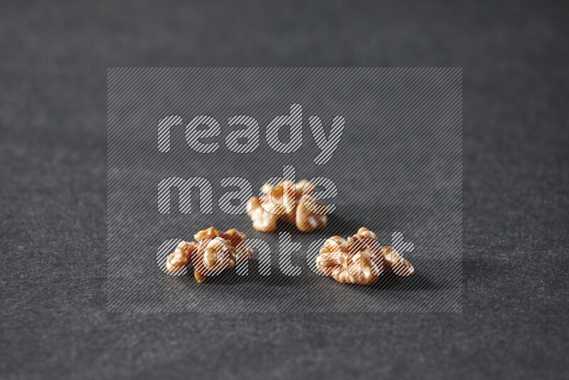 3 walnuts on a black background in different angles