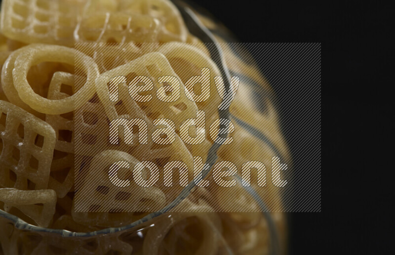 تسالي في وعاء زجاجي على خلفية سوداء