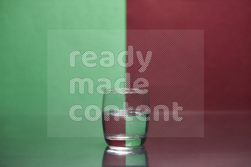 The image features a clear glassware filled with water, set against green and dark red background